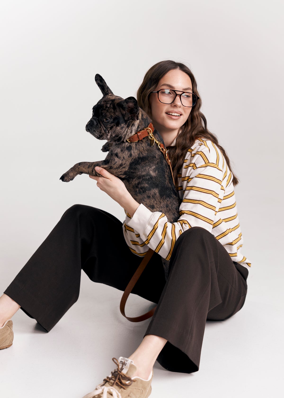Brown Aeris Classic leather dog collar and Classic leash on a dog held by its owner