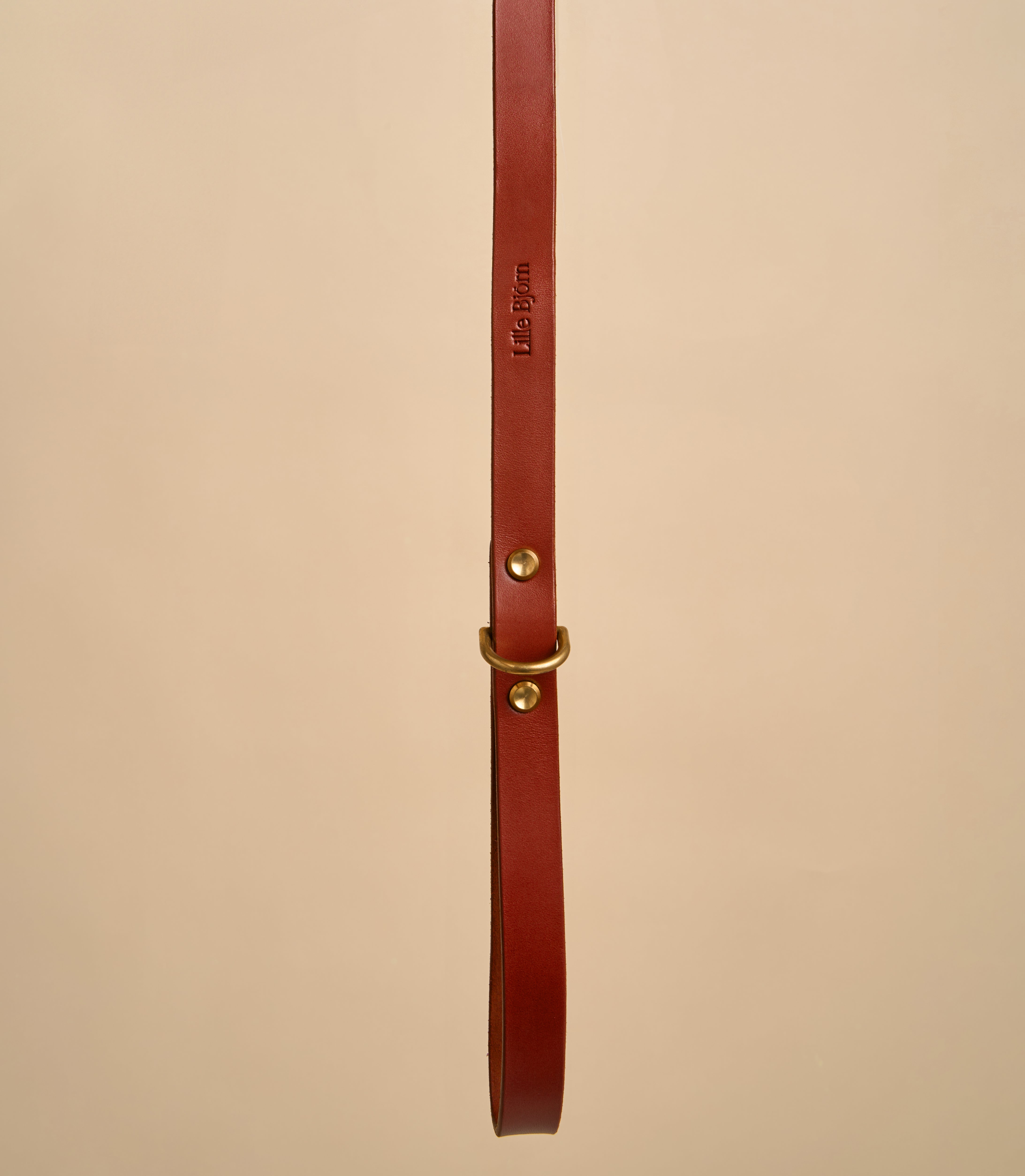 Close-up detail of Classic Cognac Leather Dog Leash handle, showing embossed design and crafted from Italian leather with durable brass hardware