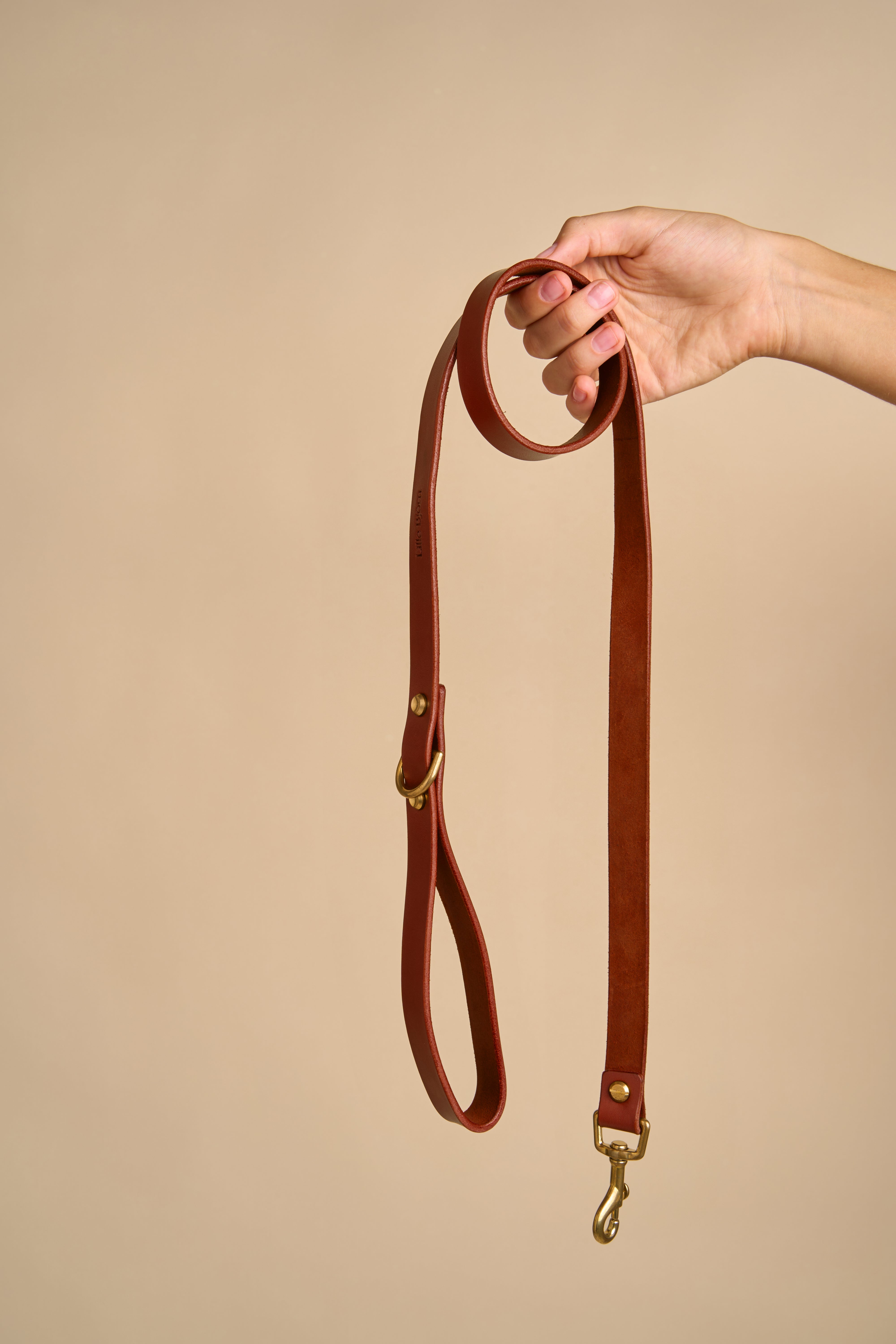 Full view of Classic Cognac Leather Dog Leash held in hand, crafted from high-quality Italian leather with durable brass hardware