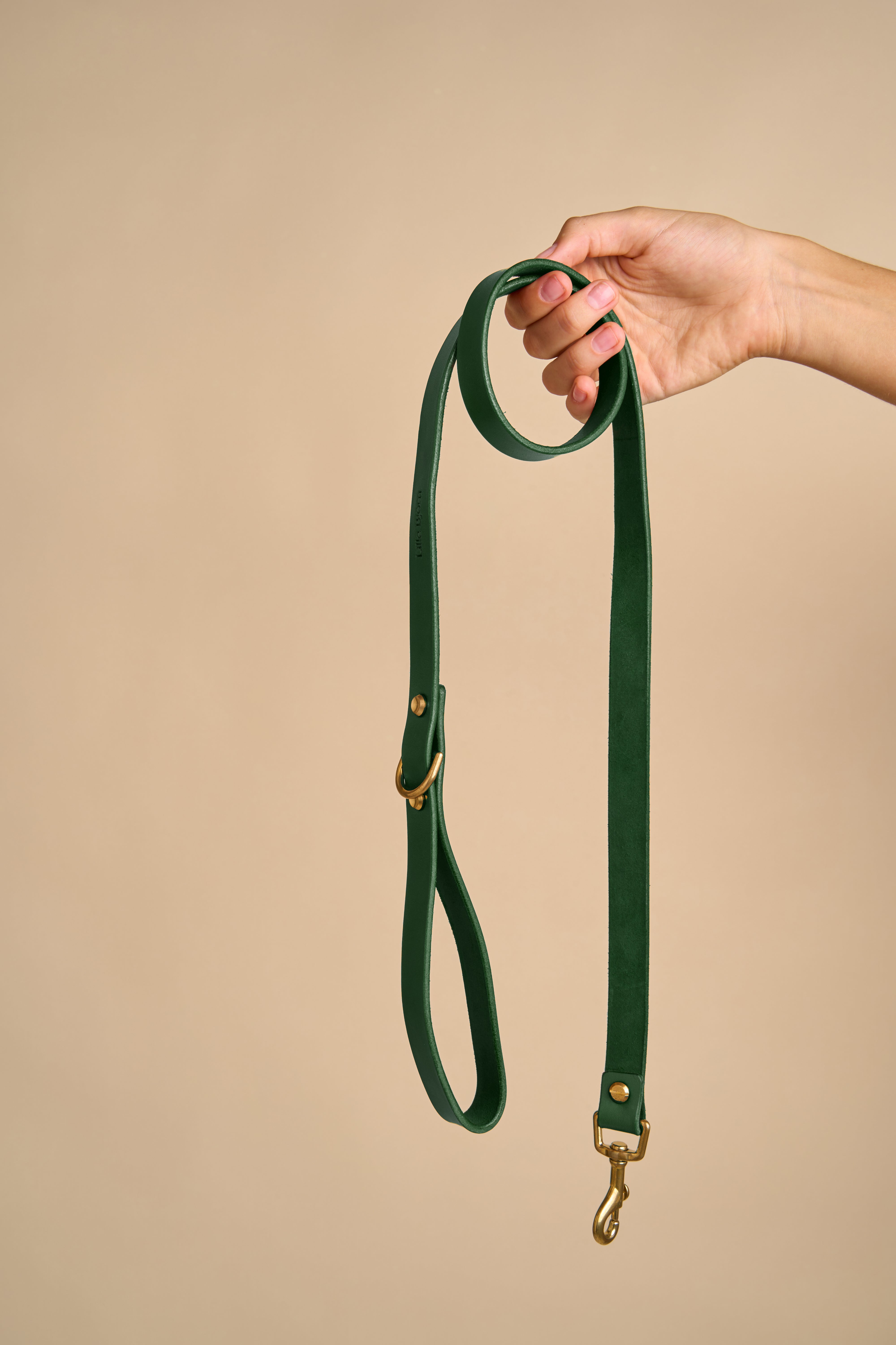 Full view of Classic Green Leather Dog Leash held in hand, showcasing Italian leather and brass hardware for durability