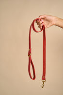 Full view of Classic Red Leather Dog Leash held in hand, made from premium Italian leather with strong brass hardware