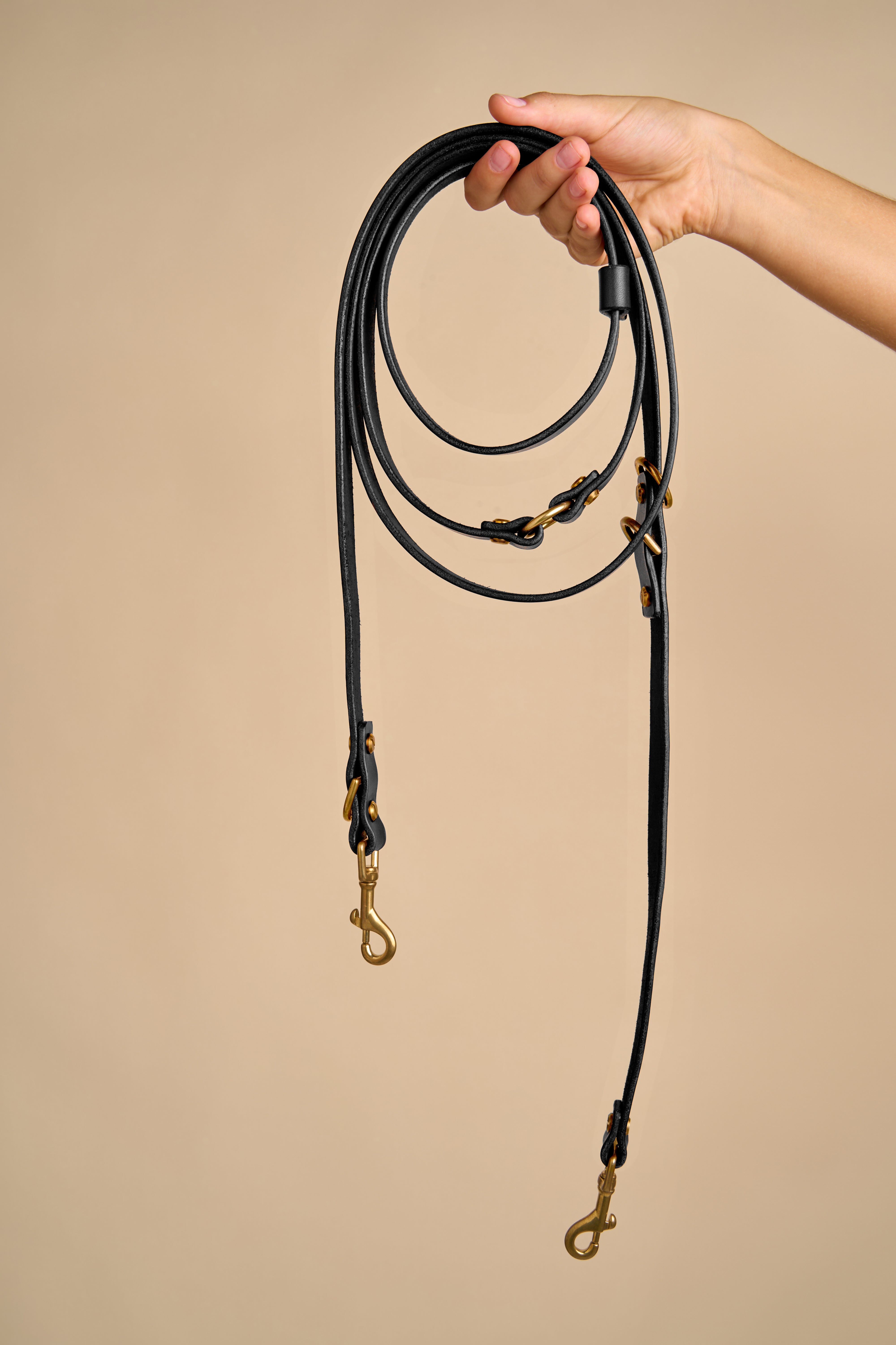 Full view of Omni Black Leather Dog Leash held in hand, crafted from Italian leather with strong brass hardware for durability