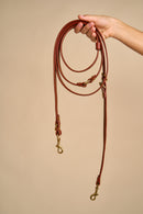 Full view of Omni Cognac Leather Dog Leash held in hand, featuring Italian craftsmanship and durable brass hardware