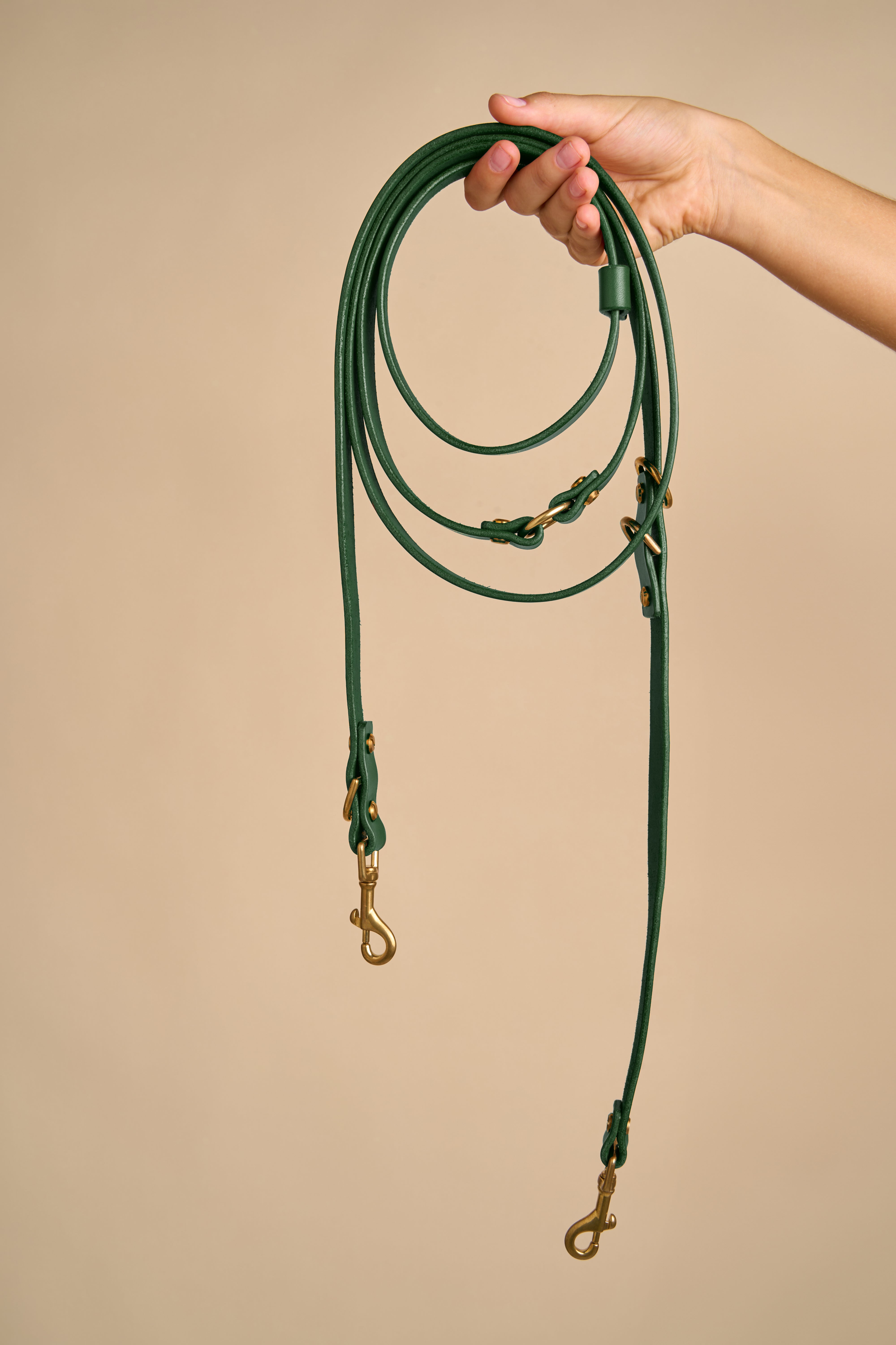 Full view of Omni Green Leather Dog Leash held in hand, showcasing Italian leather with durable brass hardware