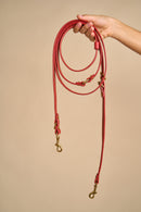 Full view of Omni Red Leather Dog Leash held in hand, made with premium Italian leather and sturdy brass hardware