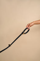 Omni Black Leather Dog Leash held in hand, showcasing versatile wear options and sturdy brass hardware